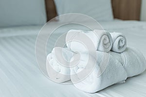 Roll of white towel on the bed table in Luxury modern hotel room
