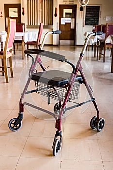 Rollator walker with a seat and a basket in an empty hall