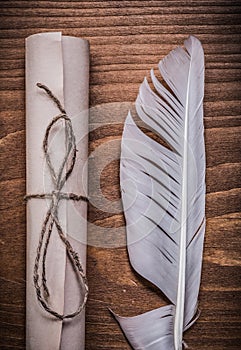 Rolled aged paper quill on wooden board