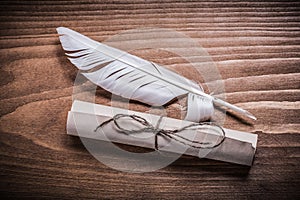 Rolled aged paper quill on wooden board horizontal