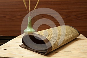 Rolled bamboo place mats on wood background