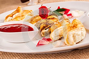 Rolled crepes stuffed with curd and berry jam