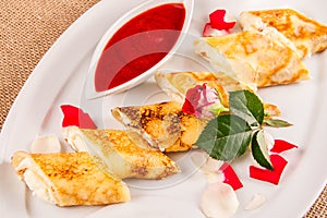 Rolled crepes stuffed with curd and berry jam