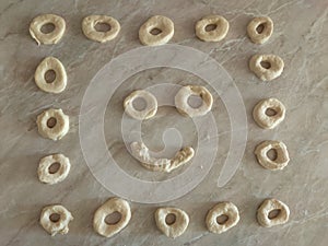 Rolled Dough for donuts. Cutting from fresh dough for traditionally donuts. Dough for donuts that smile.