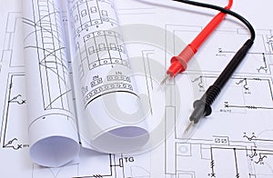 Rolled electrical diagrams and cables of multimeter on drawing of house