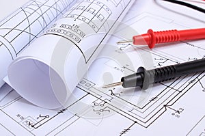 Rolled electrical diagrams and cables of multimeter on drawing of house