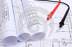 Rolled electrical diagrams and cables of multimeter on drawing of house