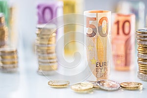 Rolled euro banknotes and coins towers stacked in other positions