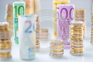 Rolled euro banknotes and coins towers stacked in other positions