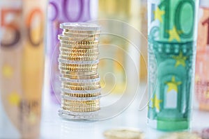 Rolled euro banknotes and coins towers stacked in other positions