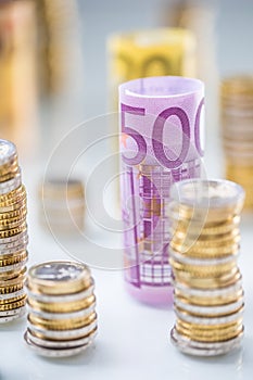 Rolled euro banknotes and coins towers stacked in other positions