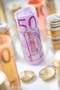 Rolled euro banknotes and coins towers stacked in other positions