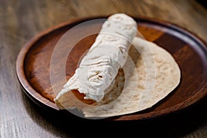 rolled flatbread pita on a round wooden cutting board. bakery. flat bread