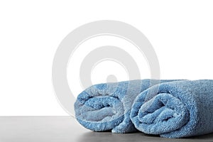 Rolled fresh clean towels for bathroom on table against background. Space for text