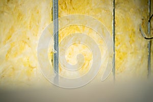 Rolled glass wool is laid between a metal profile in a frame interior partition. Filling a post-wall with soundproofing