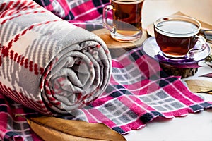 Rolled grey polar blanket on pink blanket with two cups traditional Turkish te