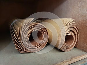 Rolled grit sand paper in a wood shelf