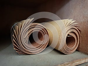 Rolled grit sand paper in a wood shelf