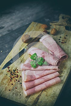 Rolled ham slices with herbs on a table