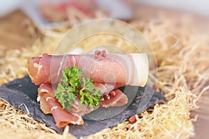Rolled ham slices with herbs on a table