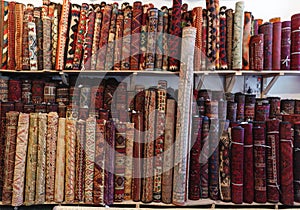 Rolled handmade Persian carpets on shelf in souvenir store