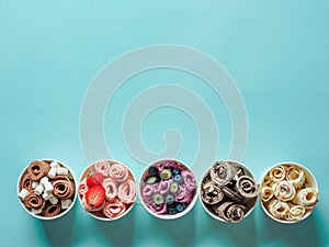 Rolled ice creams in cone cups on blue background