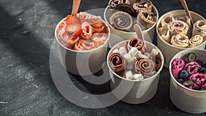 Rolled ice creams in cone cups on dark background