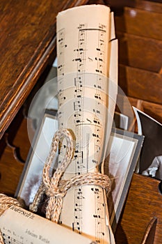 Rolled Music Sheet with aged photo over wooden drawer