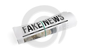 Rolled newspaper with headline FAKE NEWS on white background