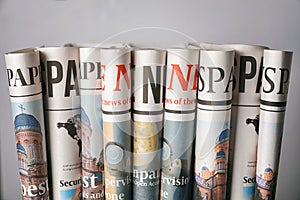 Rolled newspapers on grey background