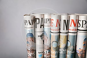 Rolled newspapers on grey background