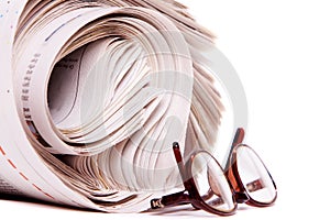 Rolled newspapers and reading glasses