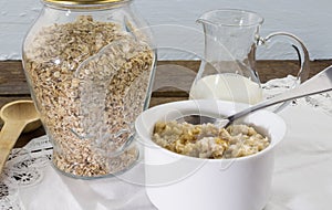 Rolled oats in bottle and cooked in bowl on table