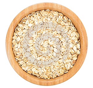 Rolled oats in wooden bowl isolated.