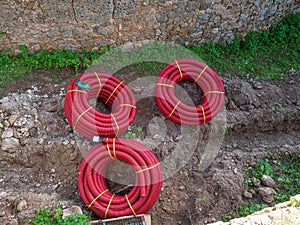 Rolled ribbed tubes. Red corrugated polymer pipes