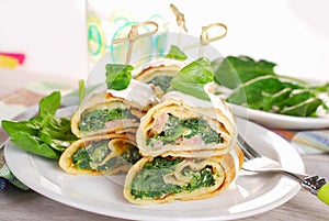 Rolled spinach pancakes as shashlik on sticks photo