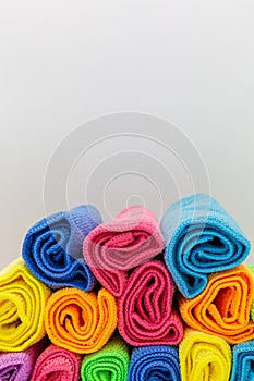 rolled towels in different colors such as blue, yellow, pink and ornage for holidays,spa and hygiene as colored background and