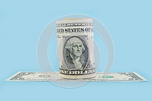 Rolled up 1 dollar bill on blue isolated background. roll of American banknotes. financial concept.