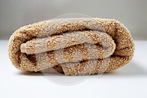 a rolled up brown towel is a hygiene and body care item