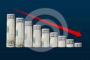 Rolled up dollar bills falling graph with red down arrow. Business concept