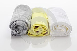 Rolled up microfibre clothes on white background