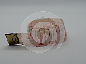 Rolled up tape measure on a white background