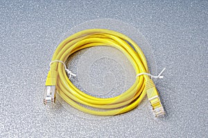 Rolled up yellow network cable or patch cable as a still life and close-up