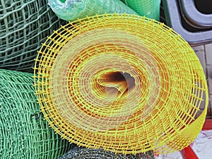 A rolled up yellow plastic polymer mesh