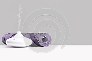 Rolled yoga mat and oil aroma diffuser