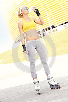 Roller blader drinking water in front of Amber Stadium