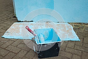 Roller with blue paint. DIY concept. incorrect wall painting