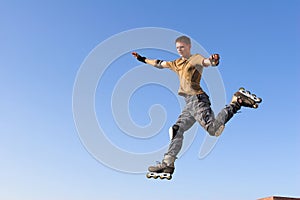 Roller boy jumping from parapet on the blue sky