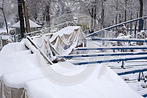 Roller coaster cowered with snow in amusement park in winter