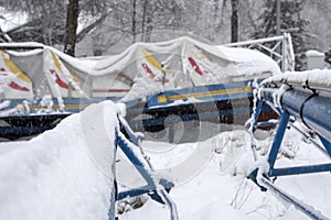 Roller coaster cowered with snow in amusement park in winter